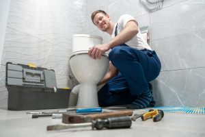 plumber-with-toolbox-fixing-a-toilet