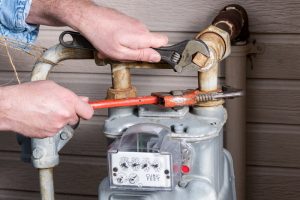 hands-holding-wrenches-working-on-a-gas-meter